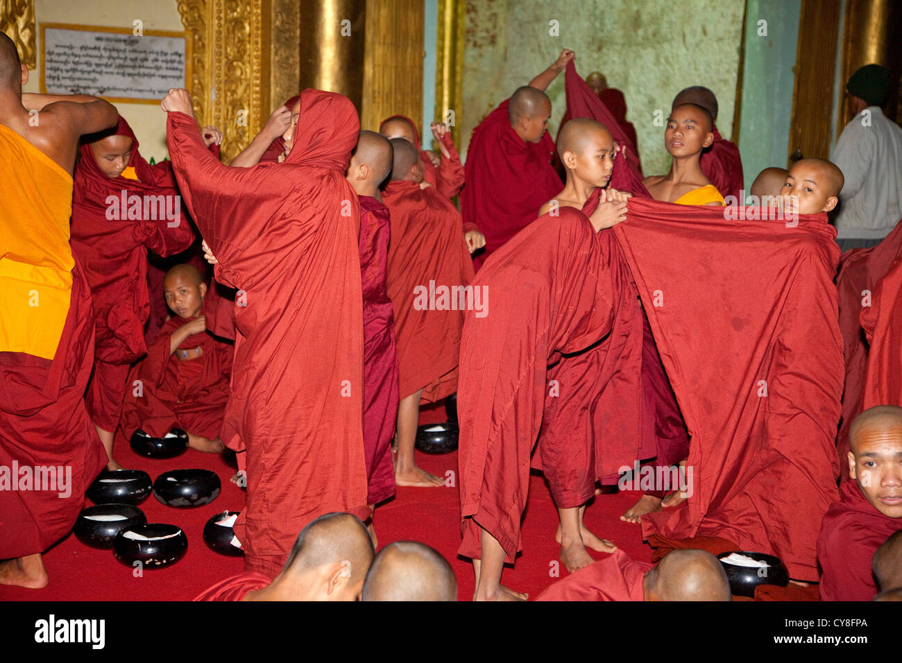 Myanmar, Burma. Young Buddhist Monks Donning Robes for a Ceremony