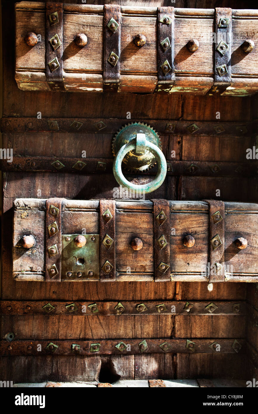 Balinese style large wooden carved doors in Bali Indonesia with metal door knocker and studs. Stock Photo