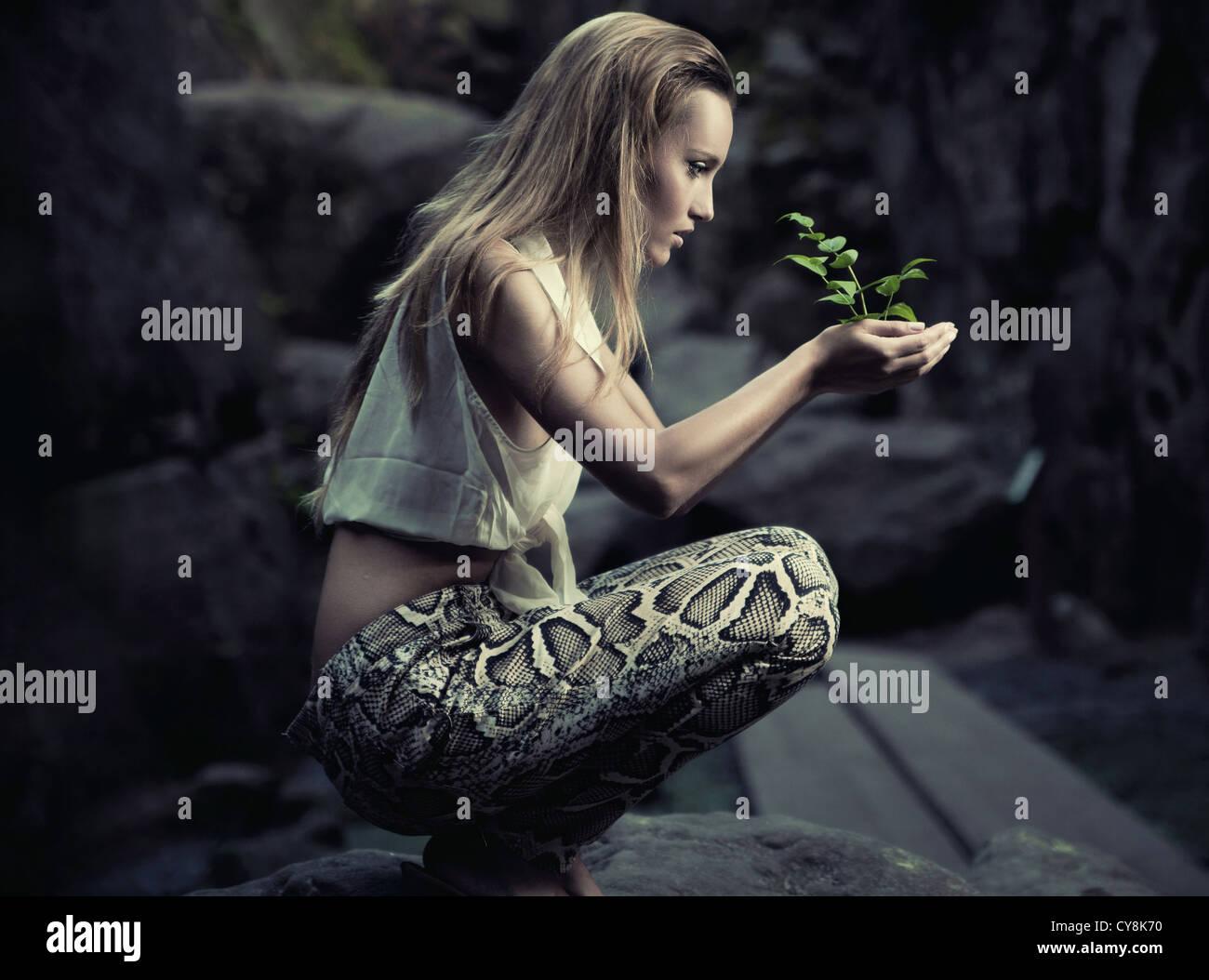 Beautiful young woman holding a plant Stock Photo - Alamy