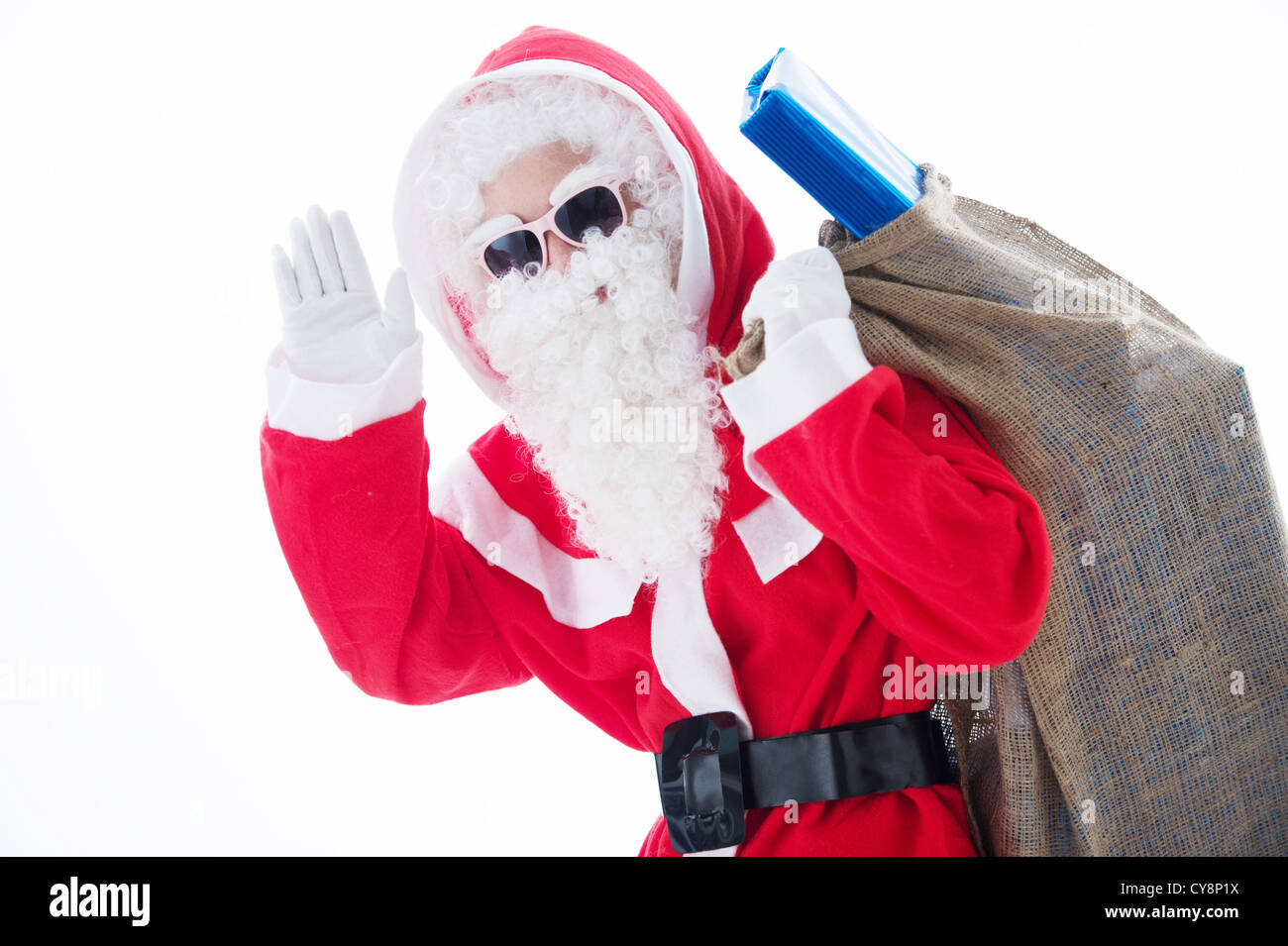 Santa Claus carrying his gift bag and waving into camera isolated on ...