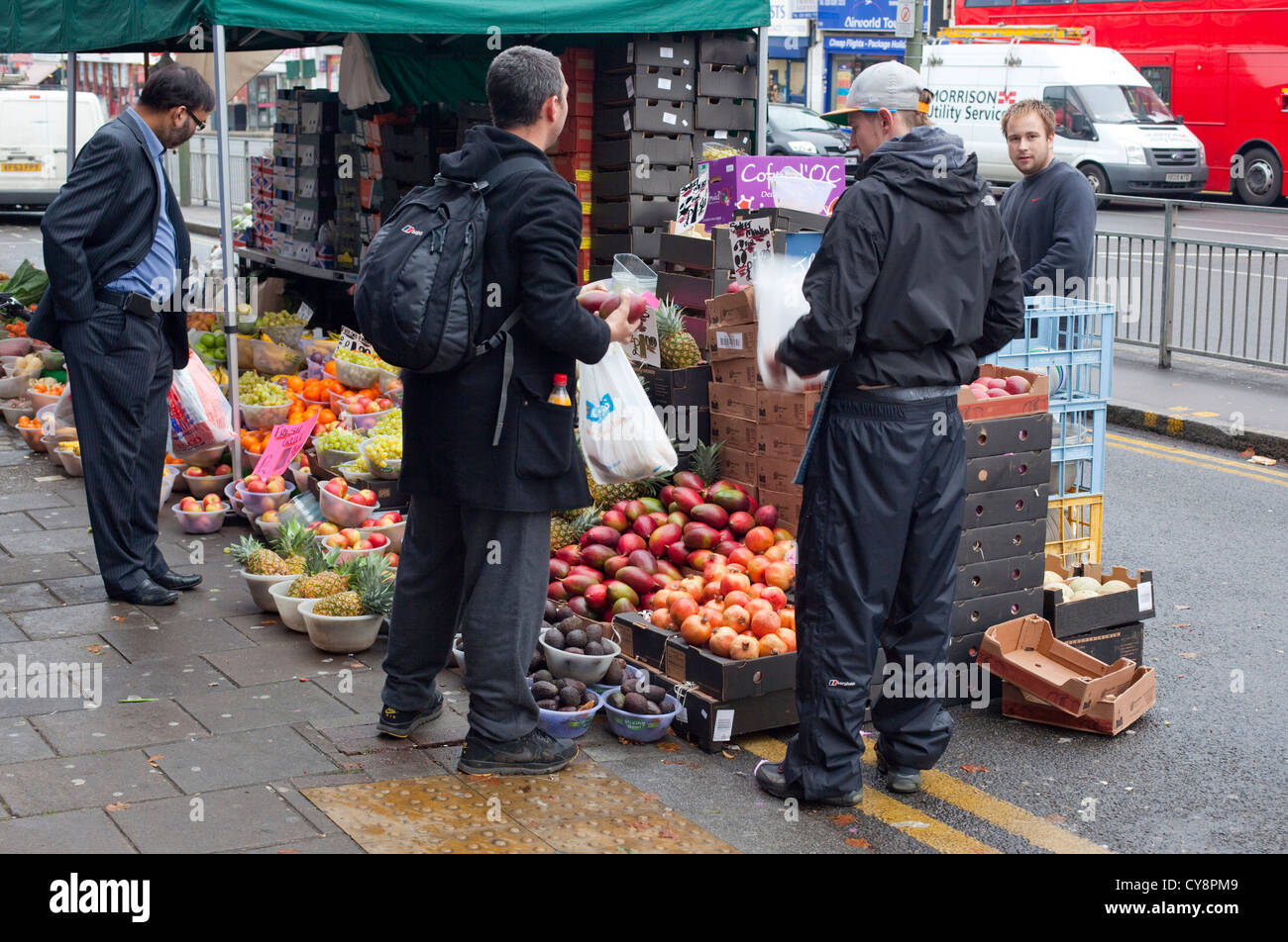 Costumers buying fruits at a fruiterer's stall, Burnt Oak, London, England, UK Stock Photo
