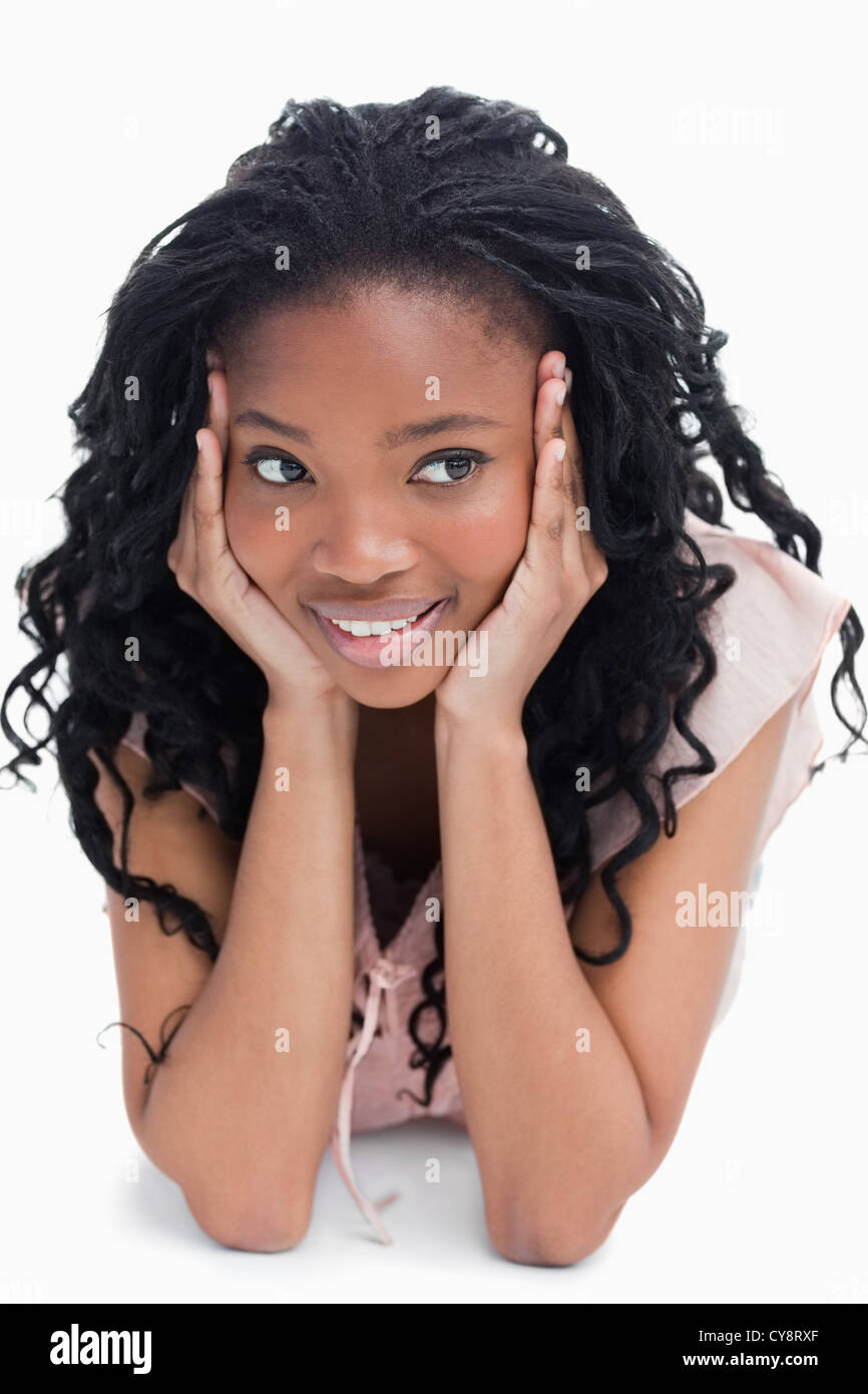 A girl resting her head on her hands is lying on the floor Stock Photo ...