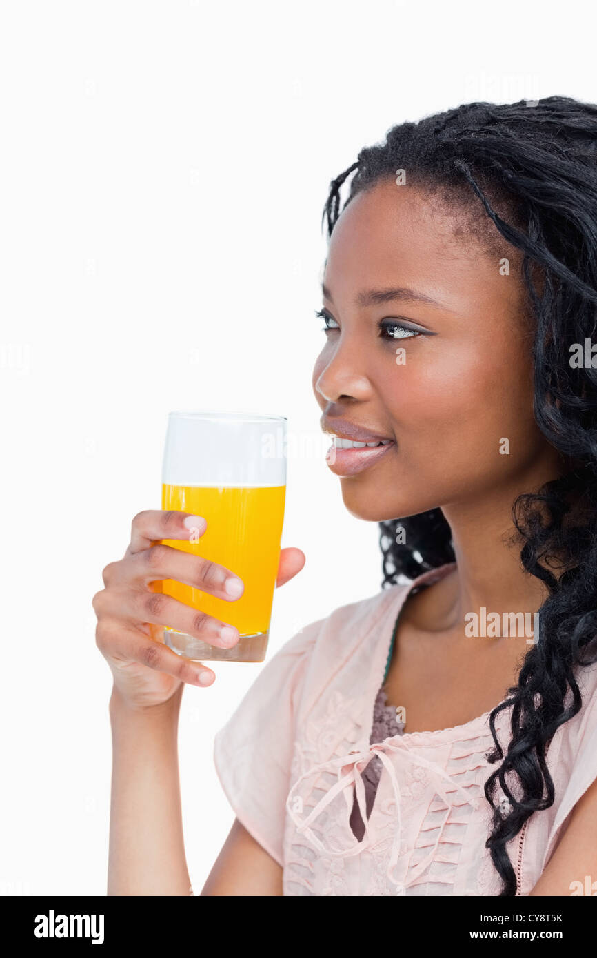 A side shot of a girl holding a glass of orange juice Stock Photo