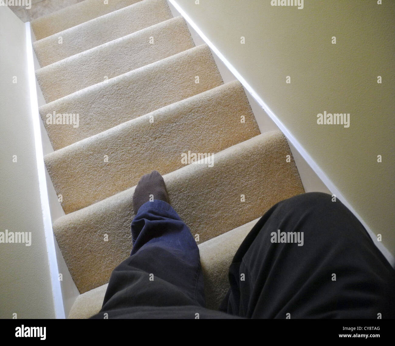 Old elderly person coming down stairs Stock Photo