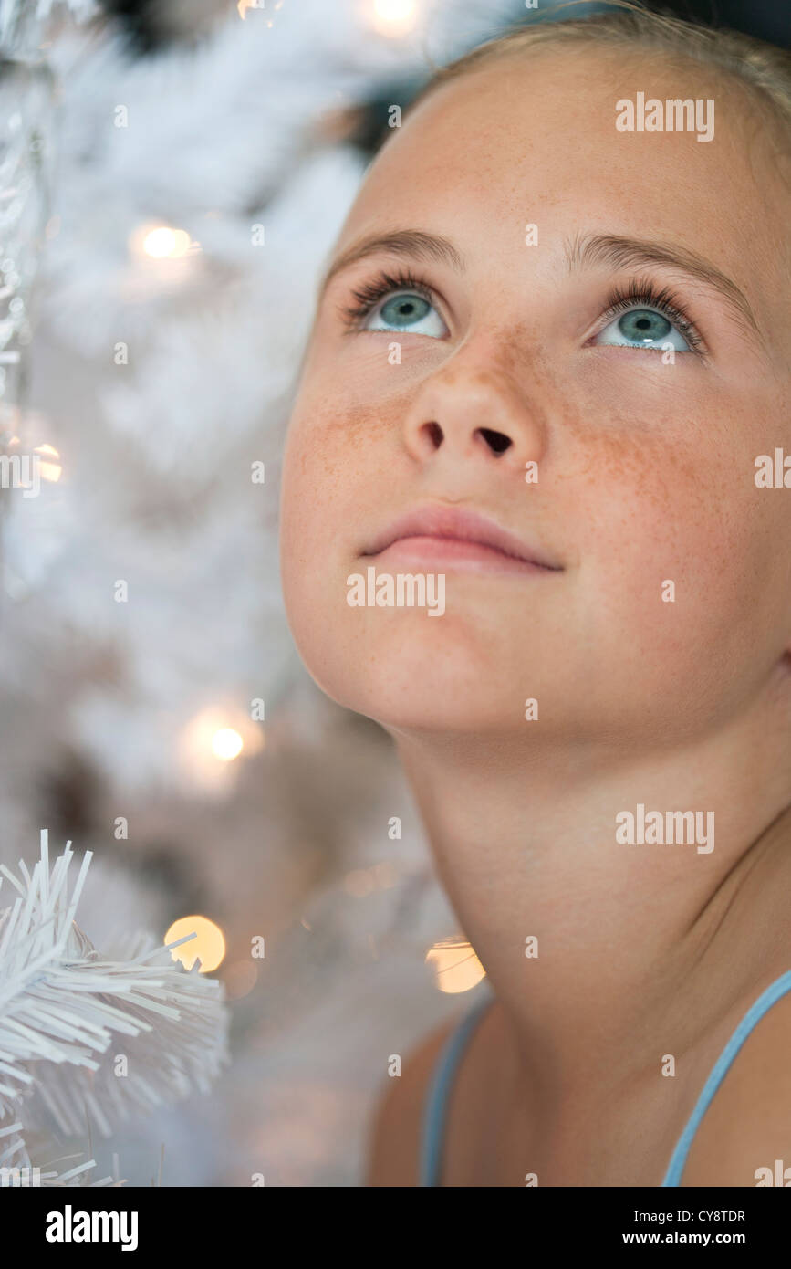 Preteen girl next to Christmas lights Stock Photo