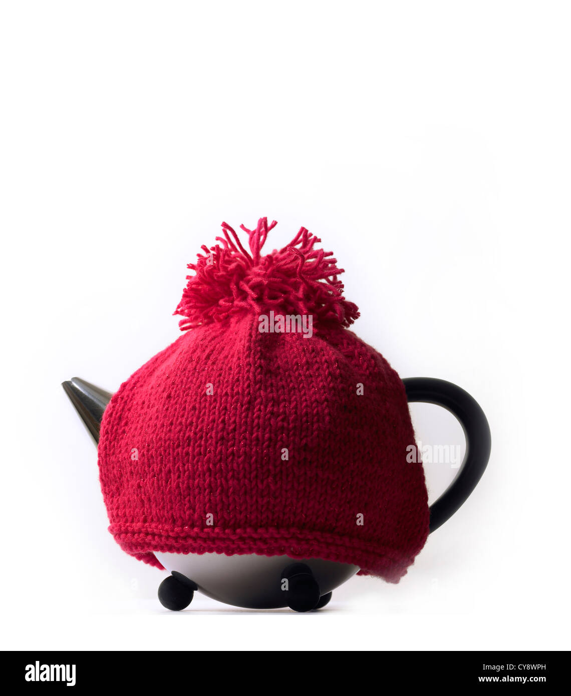 Contemporary teapot and traditional knitted red woollen tea cosy with pompom, white background Stock Photo