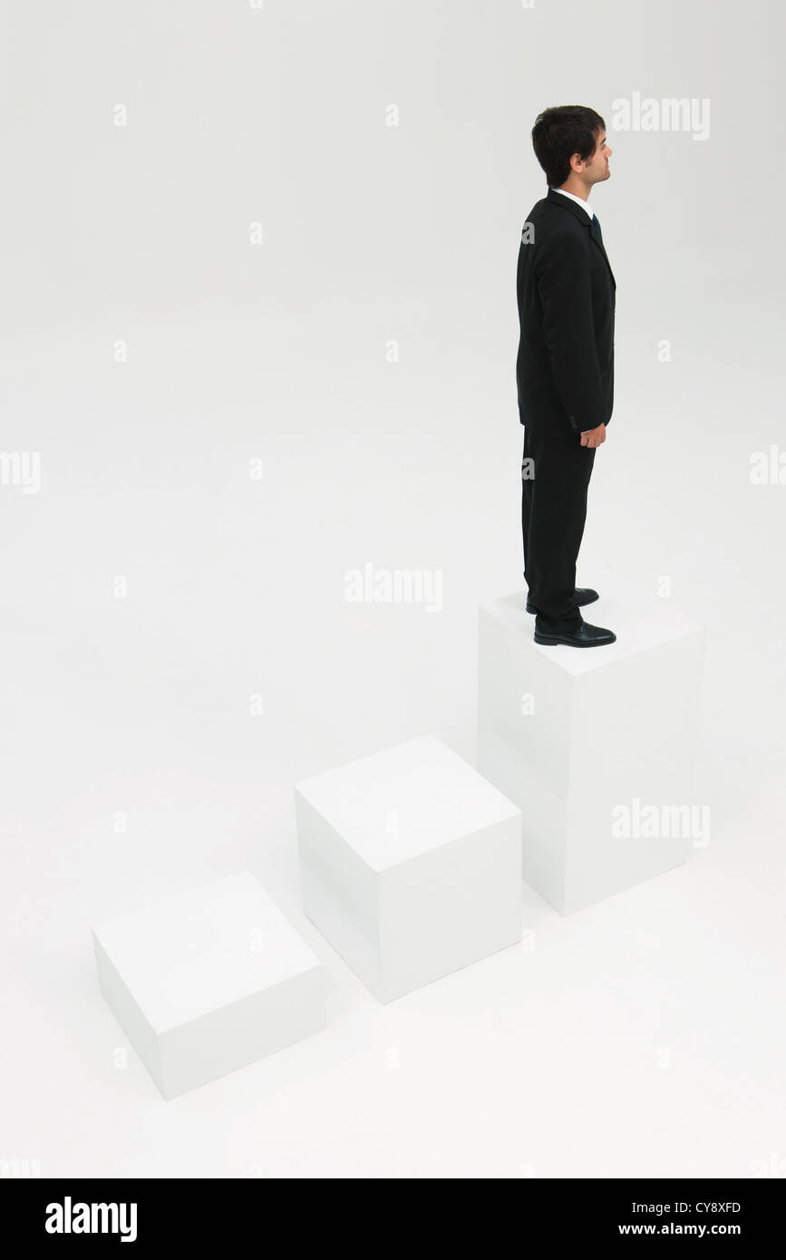 Businessman standing on highest step Stock Photo