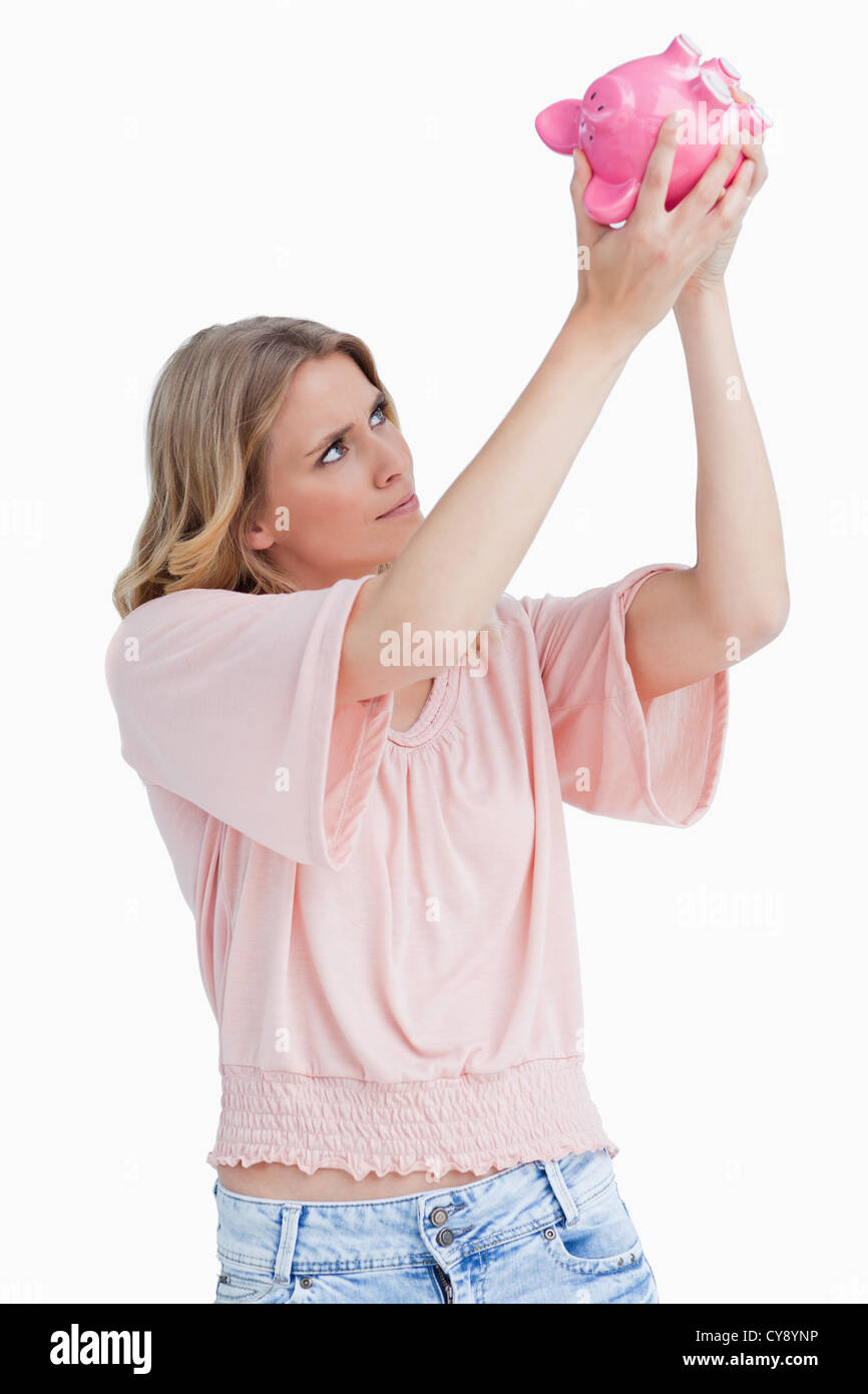 Woman looking inside of a piggy bank Stock Photo - Alamy