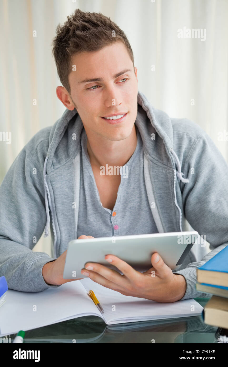 Thoughtful student using a touch pad Stock Photo Alamy