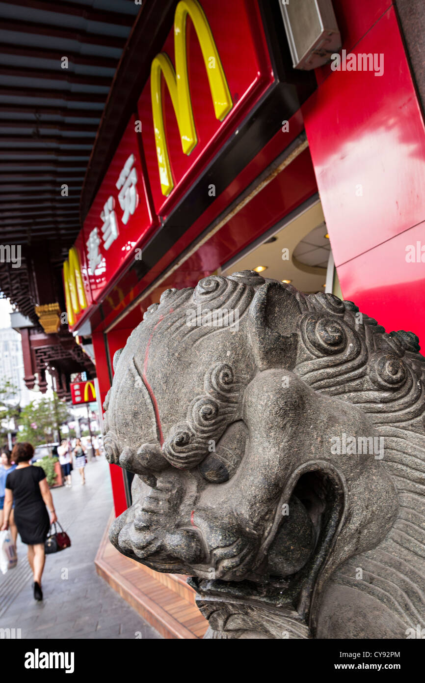 A McDonald's restaurant with a Chinese lion statue in Yu Gardens bazaar Shanghai, China Stock Photo