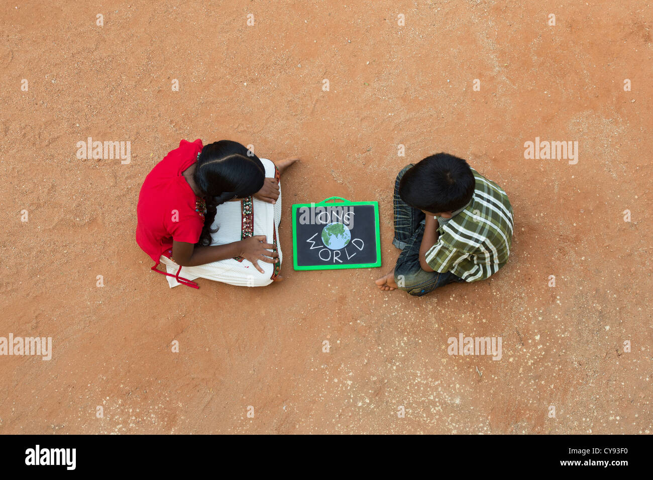 Indian village girl and boy with ONE WORLD written on a chalkboard in a rural indian village. Andhra Pradesh, India Stock Photo