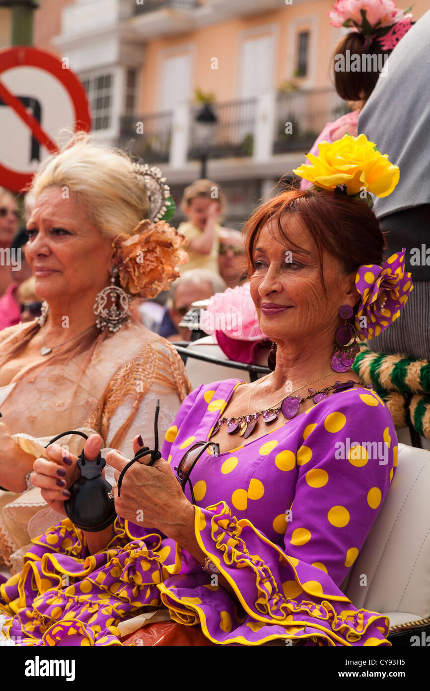 Spanish ladies ride in a carriage dressed in Spanish dress playing