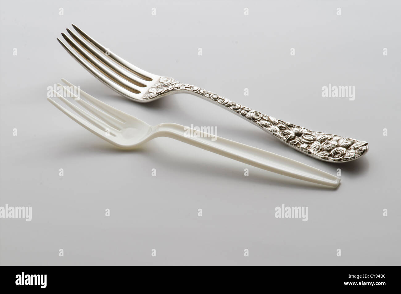 antique sterling dinner fork with cheap plastic fork Stock Photo