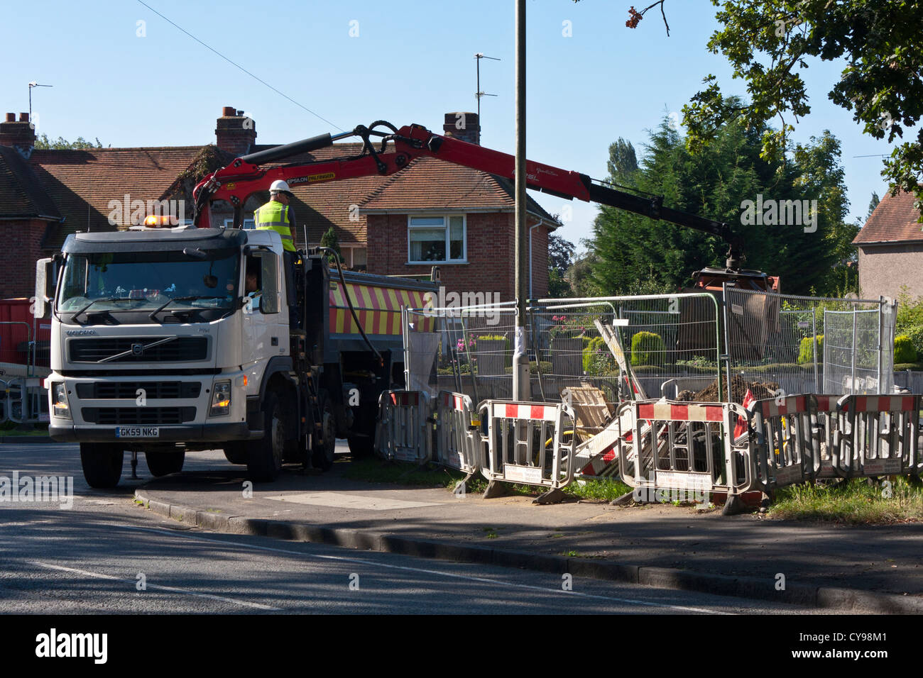 A dumper truck loads excavated soil from roadworks. Stock Photo