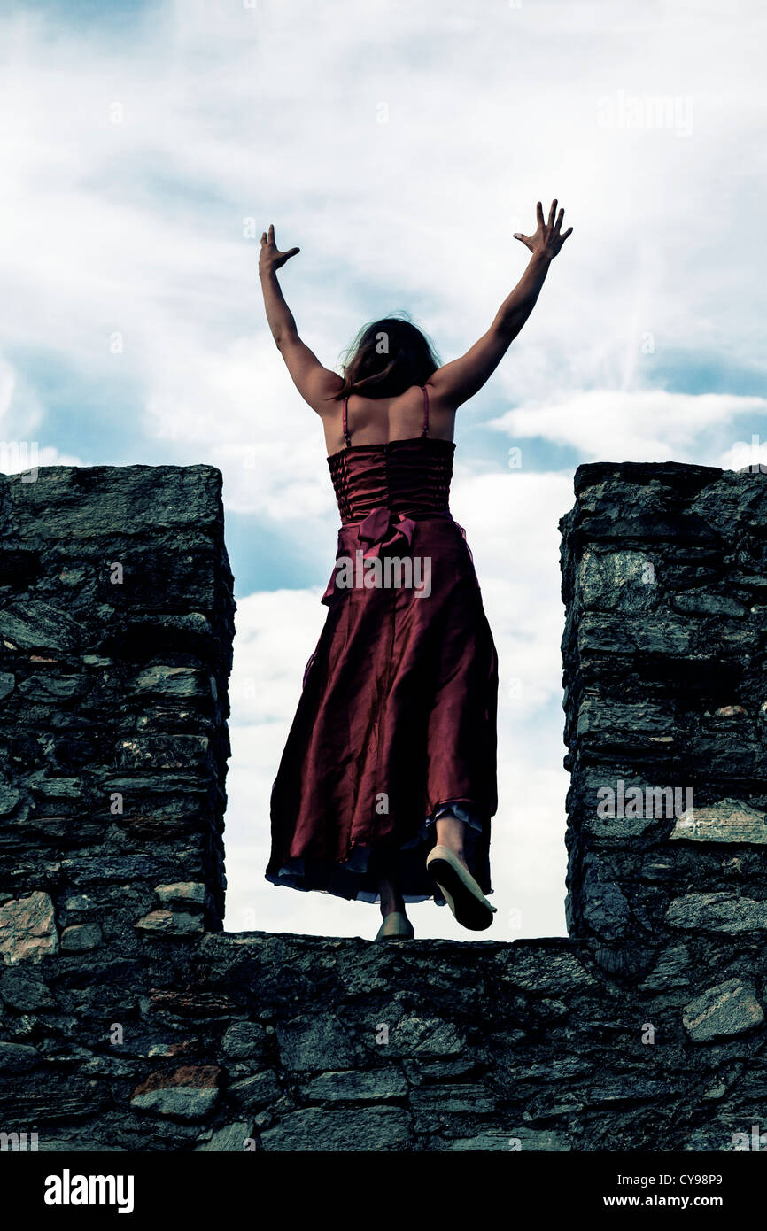 a woman on a wall springing Stock Photo