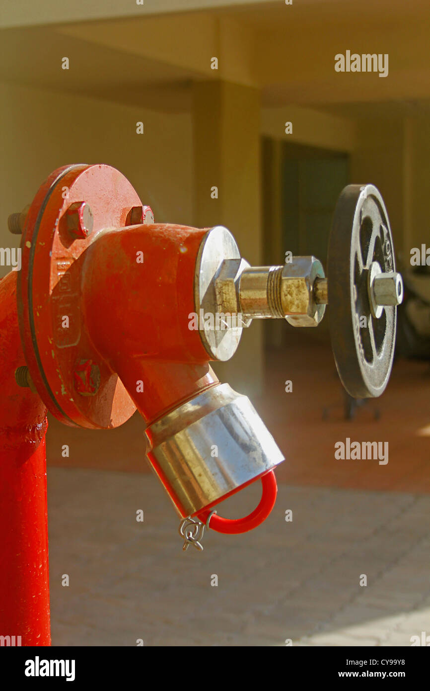 Red fire water lines in front of a building Stock Photo - Alamy