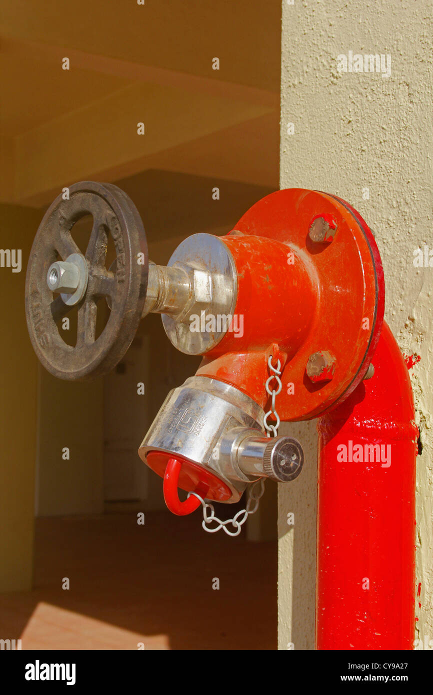 Red fire water lines in front of a building Stock Photo