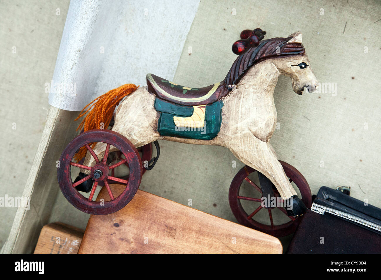 beautiful old polychrome wood miniature white hobby horse toy with orange yarn tail for sale at Hells Kitchen weekend fleamarket Stock Photo