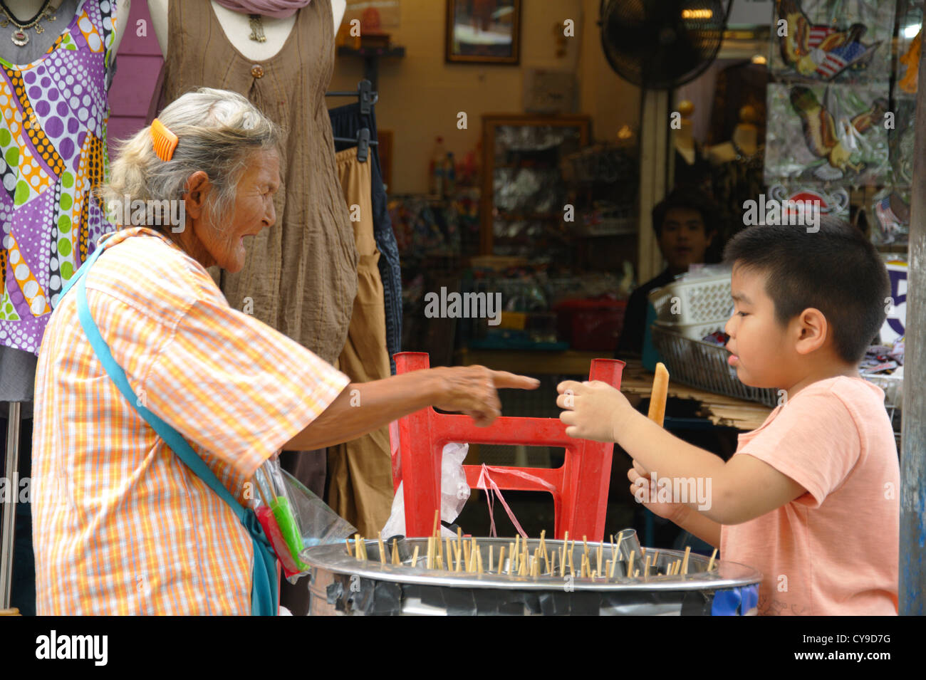 Elderly thai lady selling ice to a boy Stock Photo