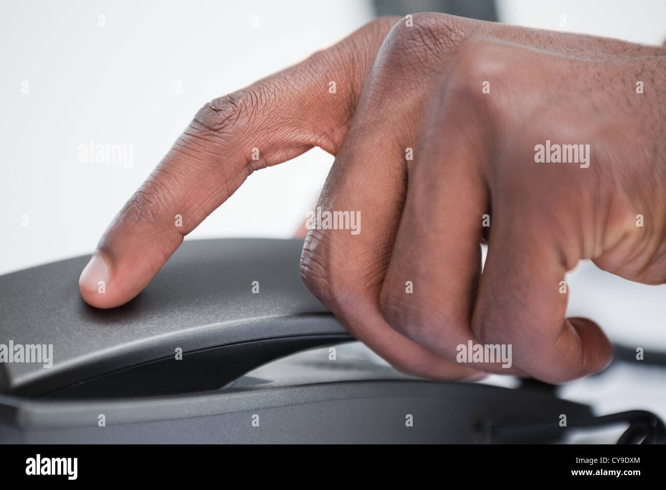 Close up of a masculine hand on a phone handset Stock Photo
