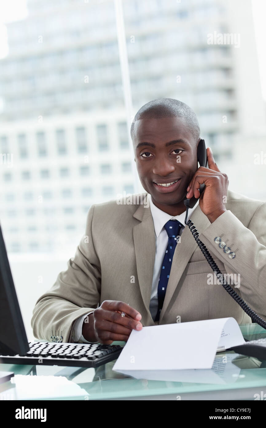 Portrait of a smiling businessman making a phone call while reading a document Stock Photo