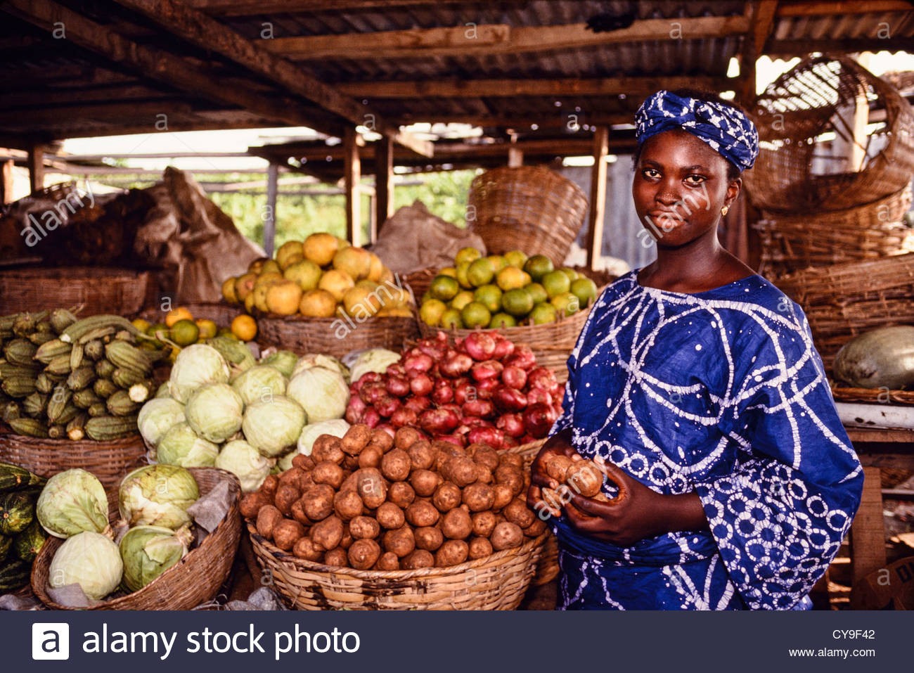 A Nigerian woman sells vegetables at an open air market near Lagos
