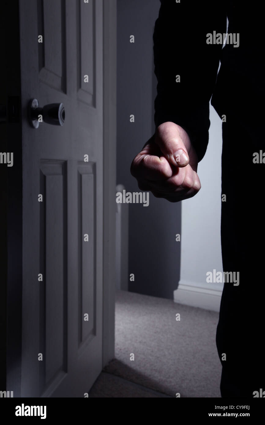 Male fist clenched entering a dark room. Model released Stock Photo