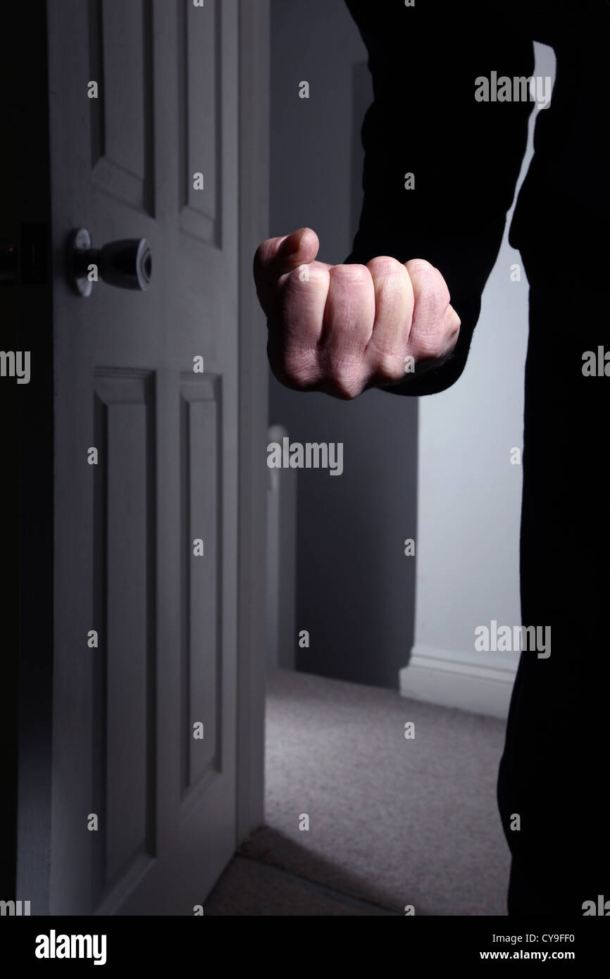 Male fist clenched entering a dark room. Model released Stock Photo