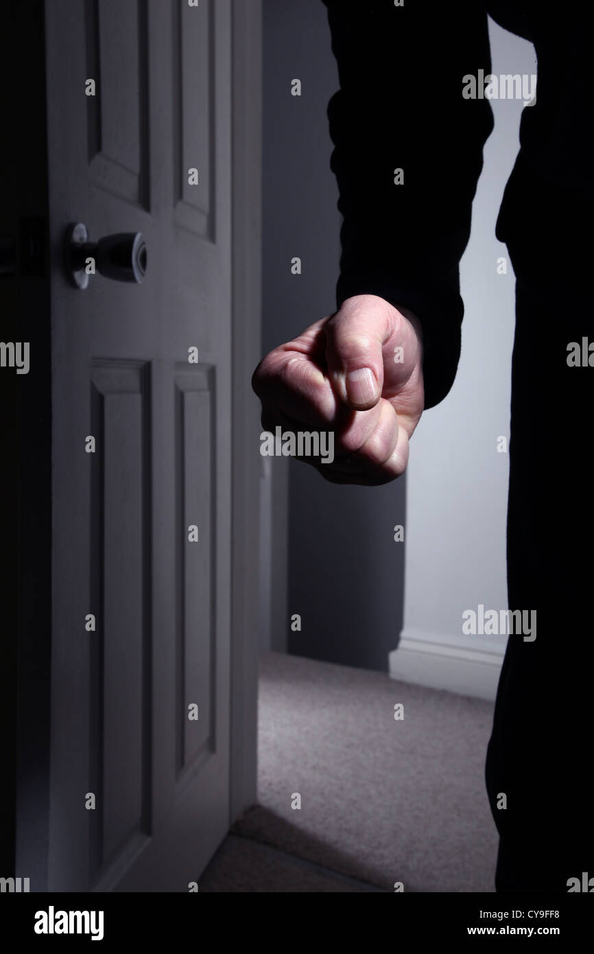 Male fist clenched entering a dark room. Model released Stock Photo