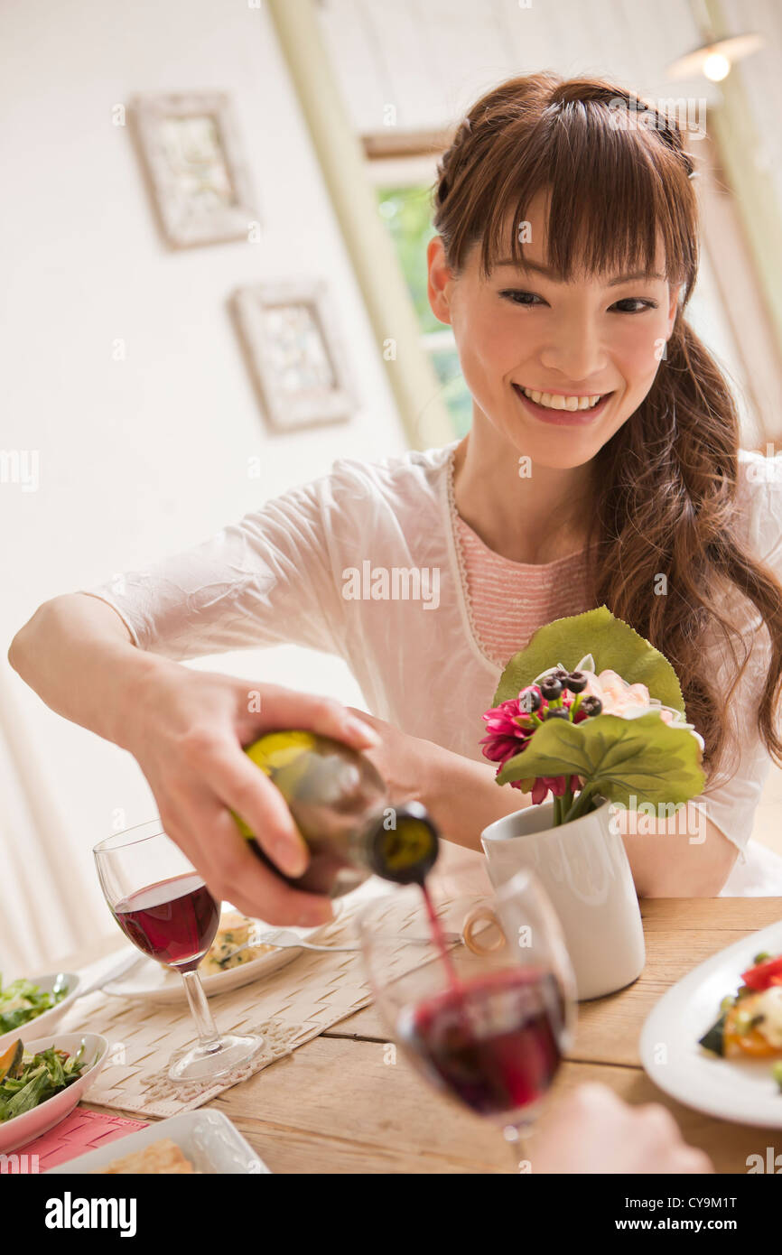 Young Woman Pouring Wine into Wine Glass Stock Photo