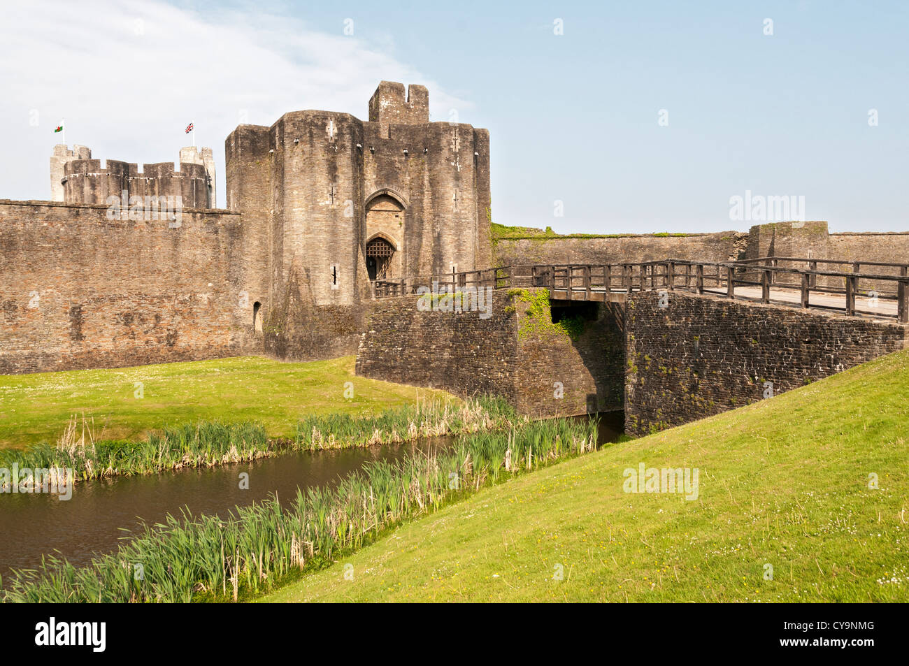 Wales, Caerphilly Castle, construction began 1268, bridge over moat, Welsh flags Stock Photo