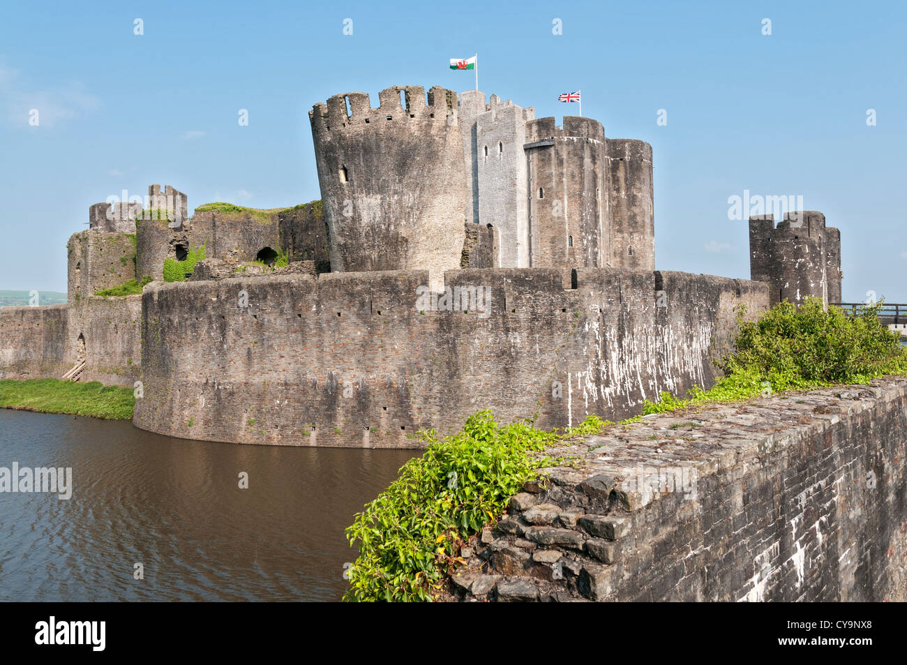 Wales, Caerphilly Castle, construction began 1268, moat, Welsh flags Stock Photo