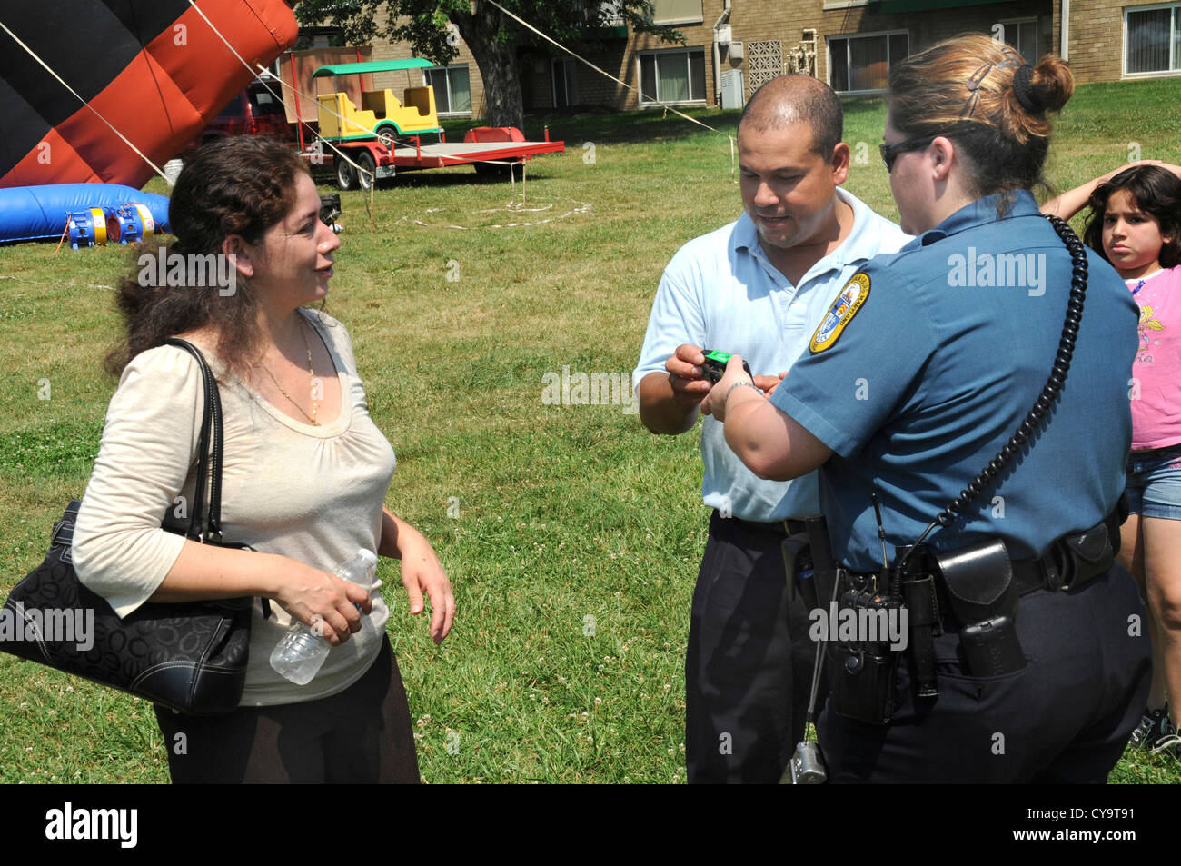 A Bladensburg policewoman helping a Hispanic couple with a camera in Edmonston, Maryland Stock Photo