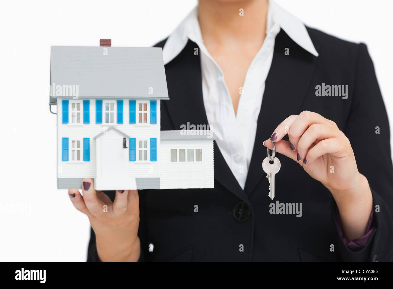 Businesswoman in suit holding a model house and key Stock Photo - Alamy