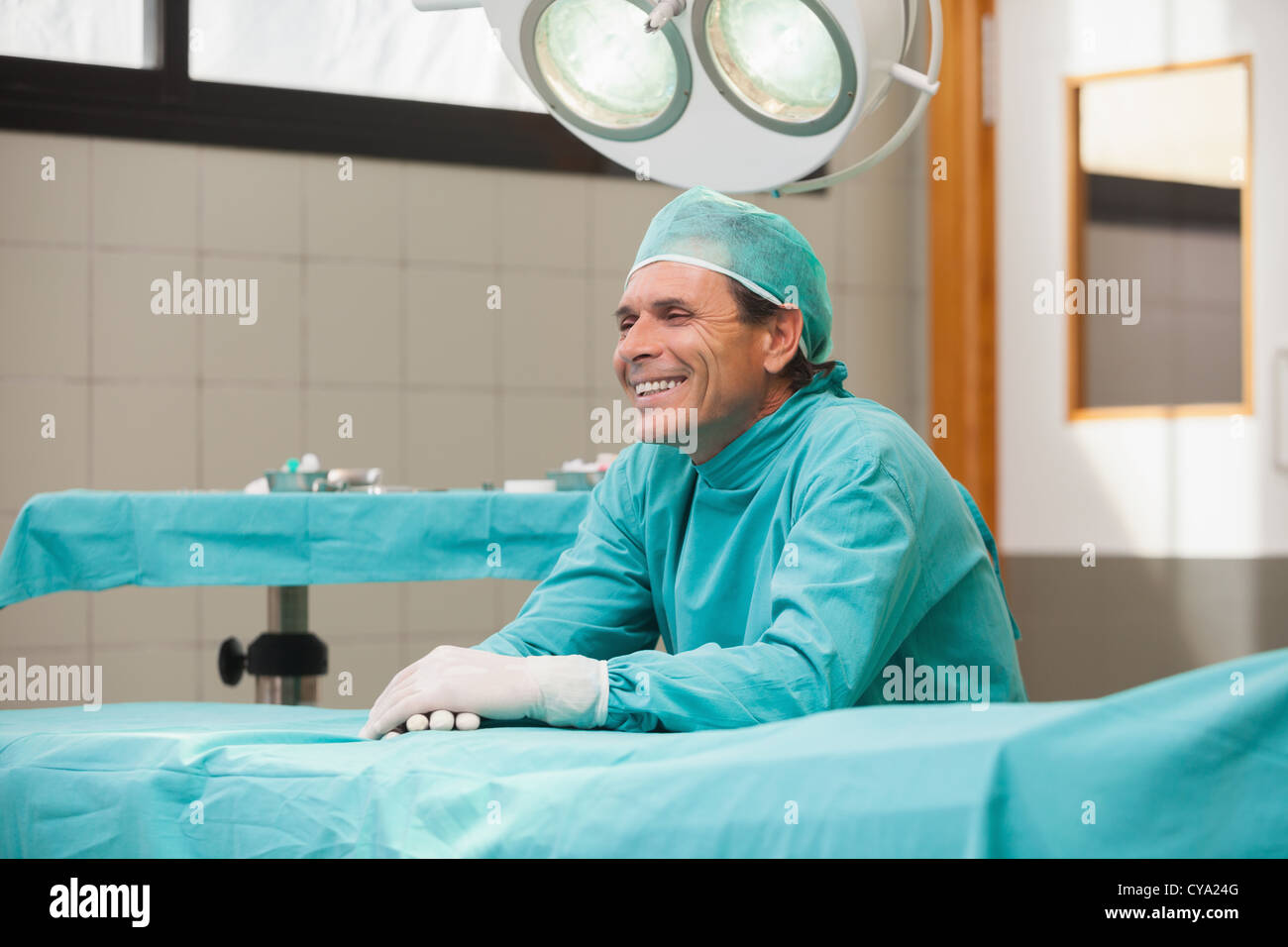 Hospital feeling. Счастливый хирург. Хирург сидит. Хирург улыбается. Радостный хирург.