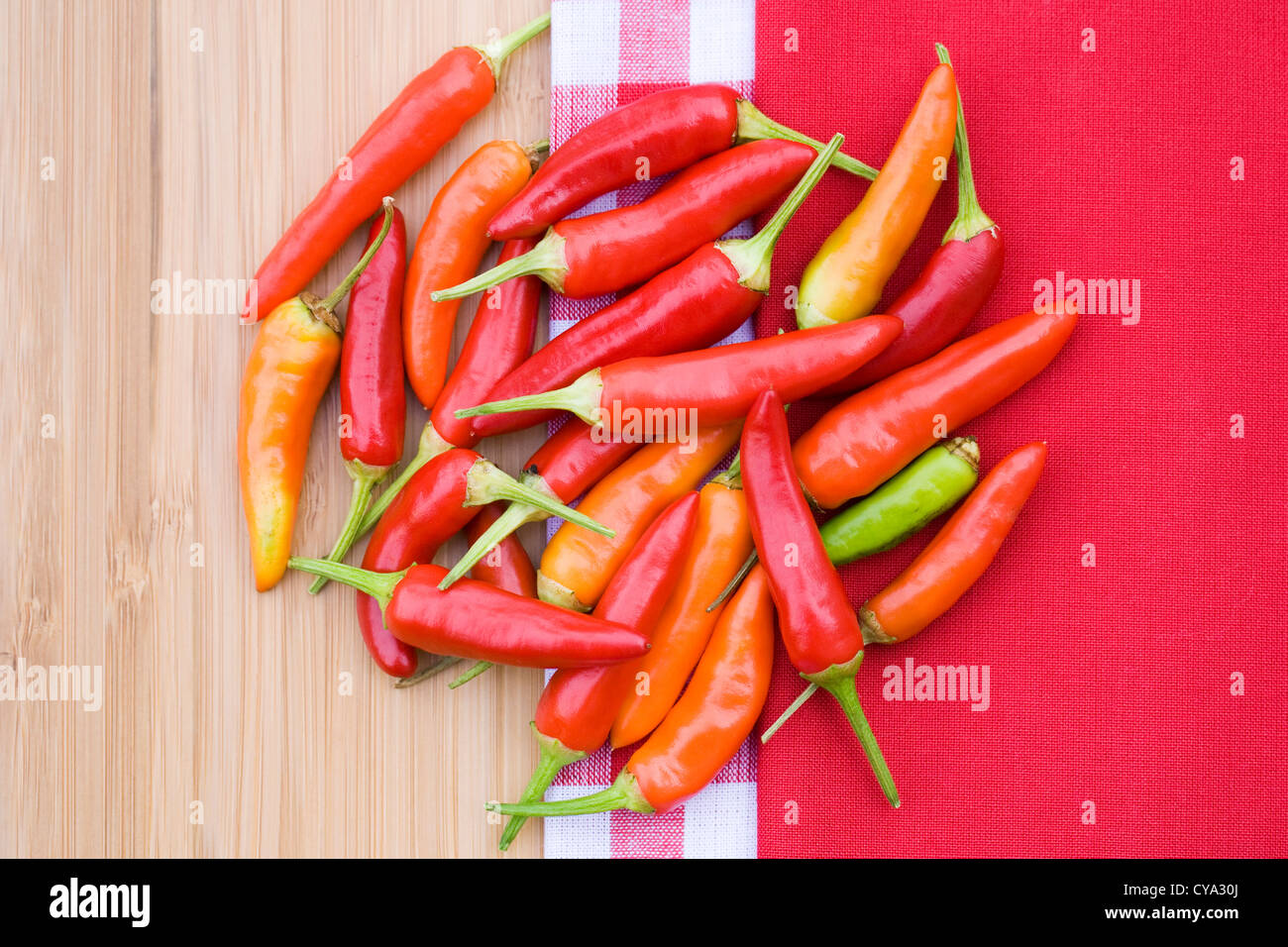 Capsicum annum 'Superchili'. Chili peppers on a bamboo board. Stock Photo