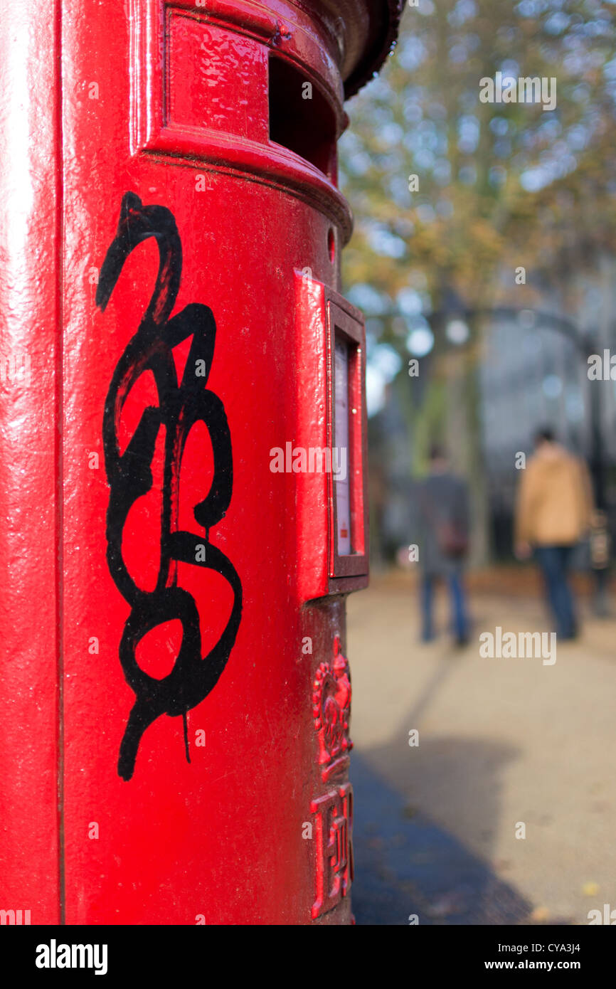 Red post Box with Graffiti on it Stock Photo