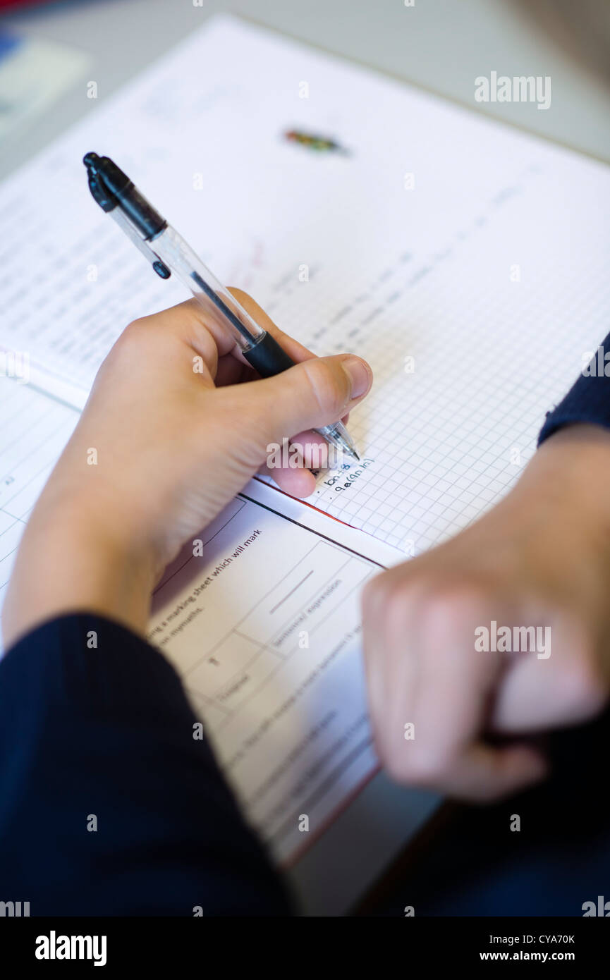 Pupils writing in a math maths lesson in a classroom of a secondary comprehensive school , Wales UK Stock Photo