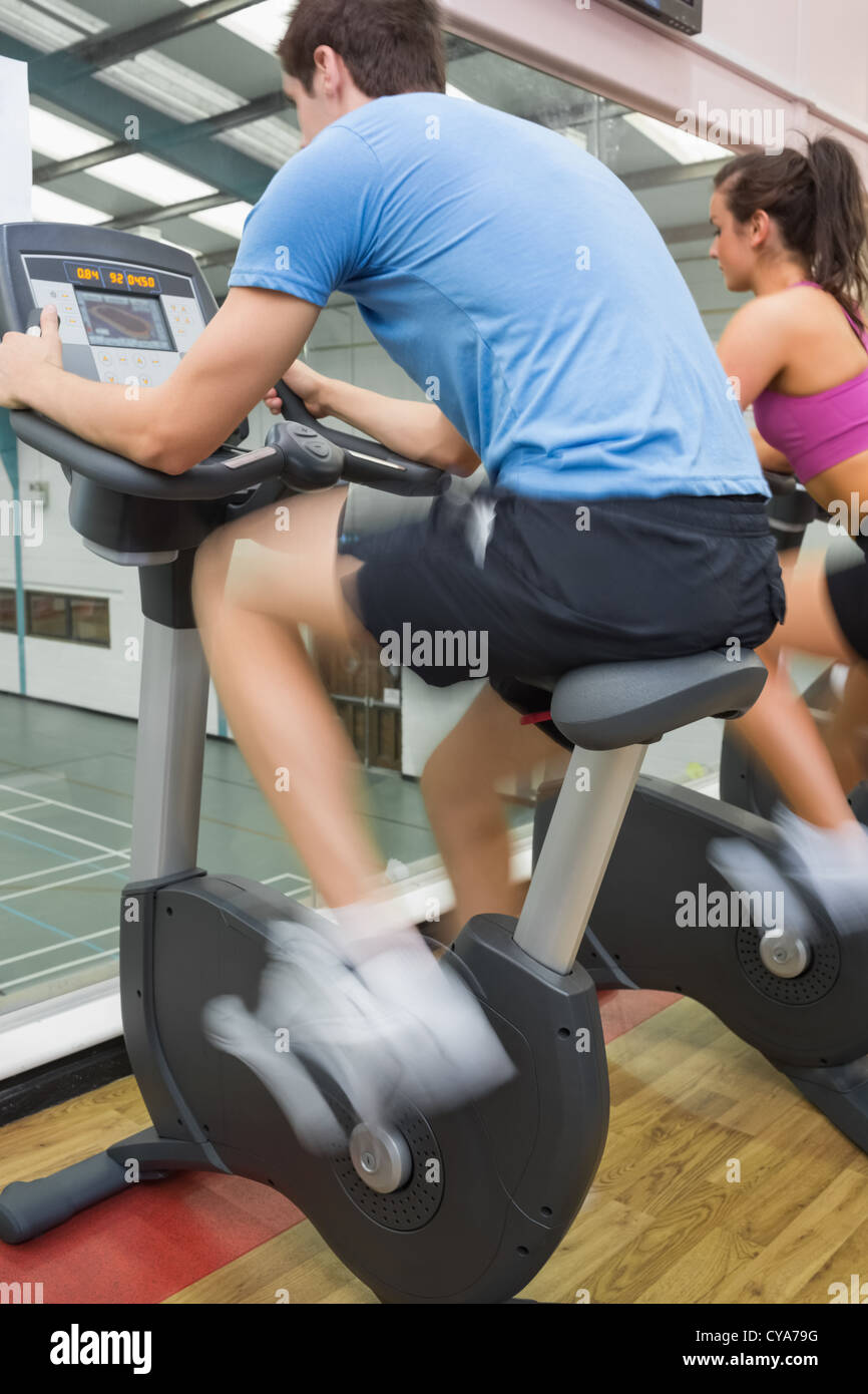 Man and woman riding on an exercise bike Stock Photo - Alamy