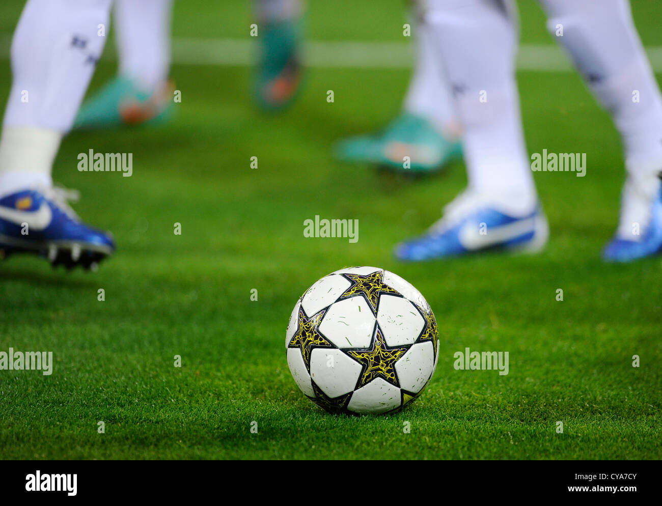 legs of football players and UEFA Champions League Balls Adidas Finale 12  OMB on football pitch Stock Photo - Alamy