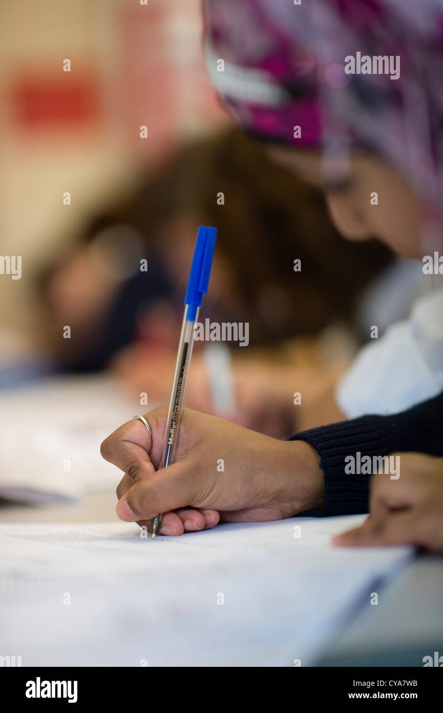 Pupils writing in a lesson in a clasroom of a secondary comprehensive school , Wales UK Stock Photo