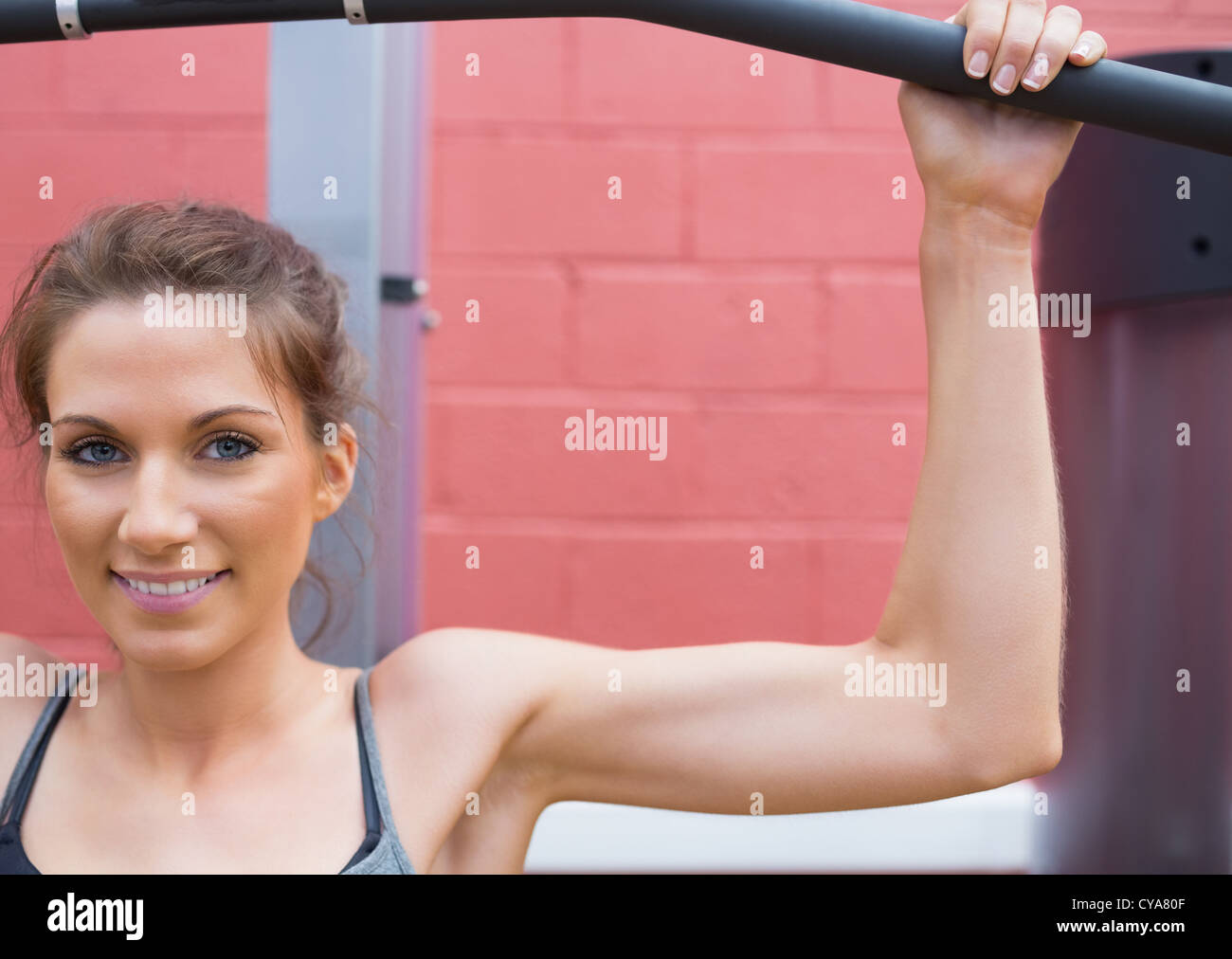 Woman smiling using weight machine Stock Photo Alamy
