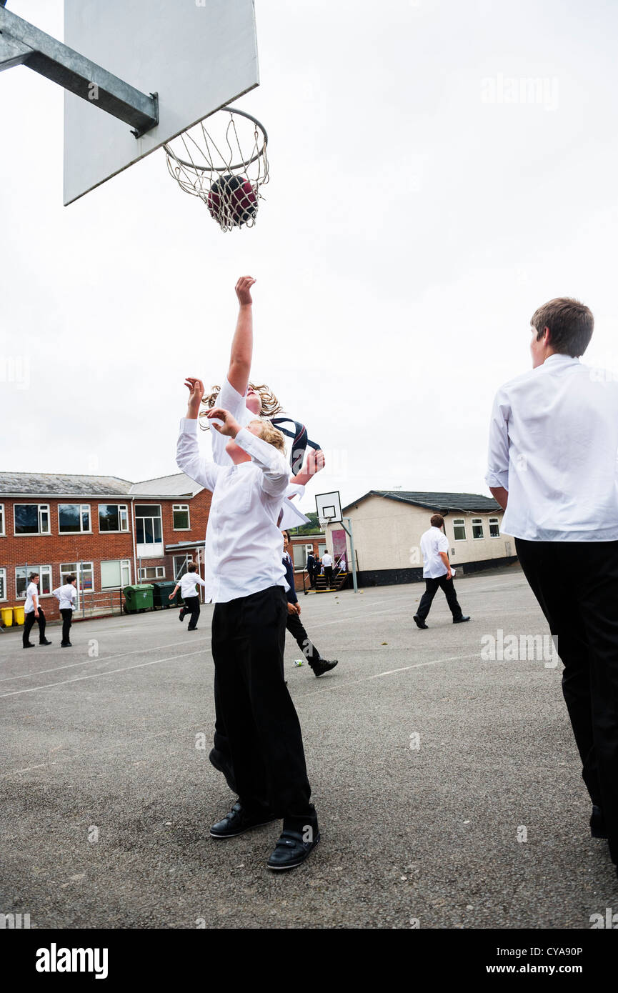 Boys playing basketball at breaktime in a secondary comprehensive school , Wales UK Stock Photo