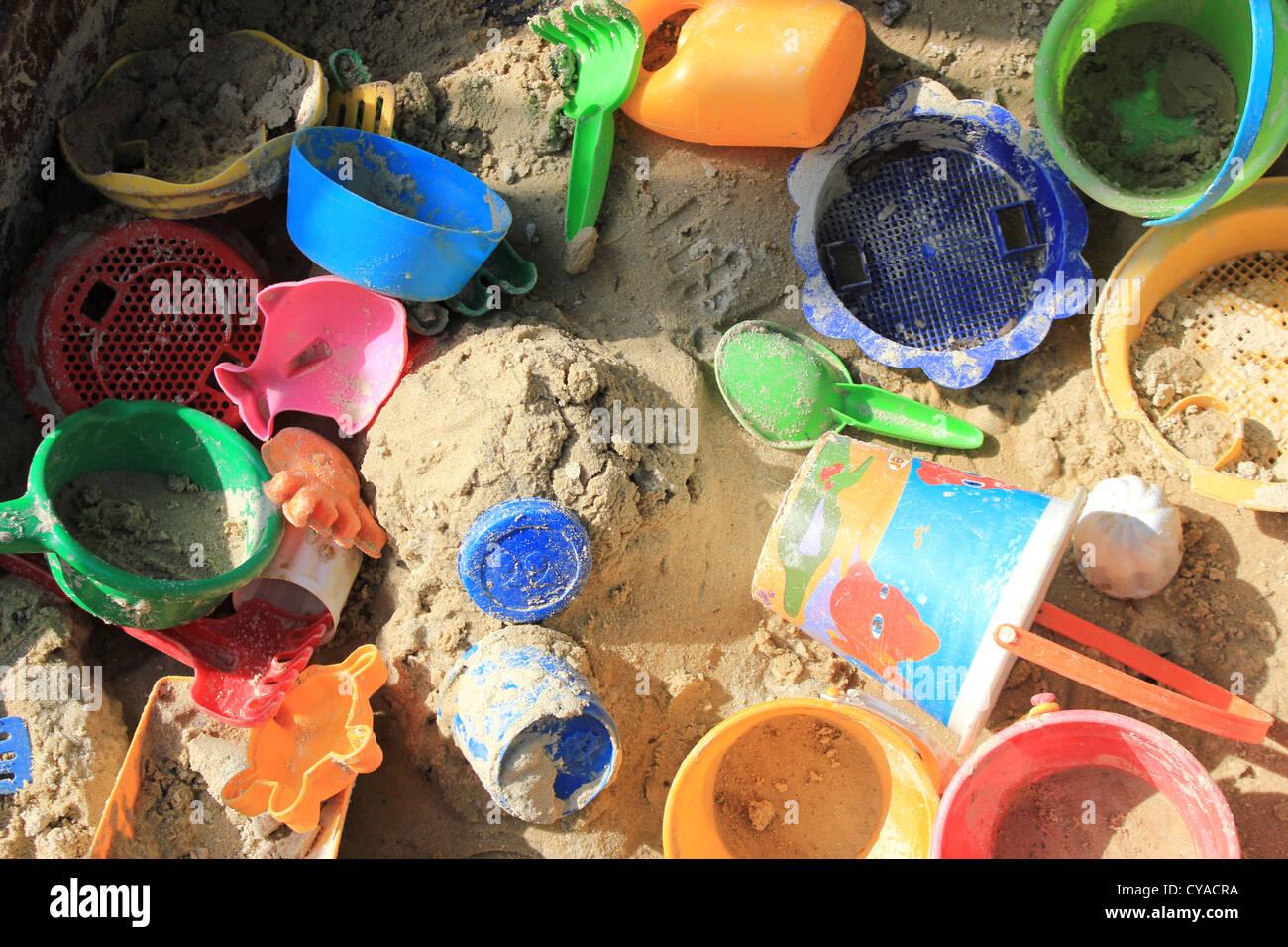 Sandpit full of plastic toys in bright colours Stock Photo