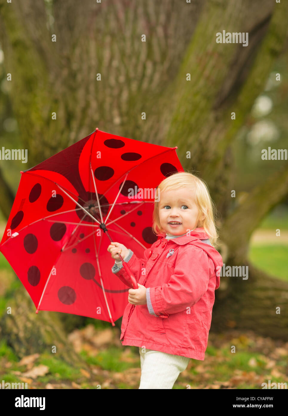 Portrait of happy baby with red umbrella outdoors Stock Photo