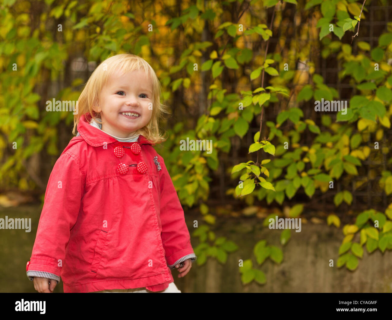 Portrait of happy baby in red coat outdoors Stock Photo