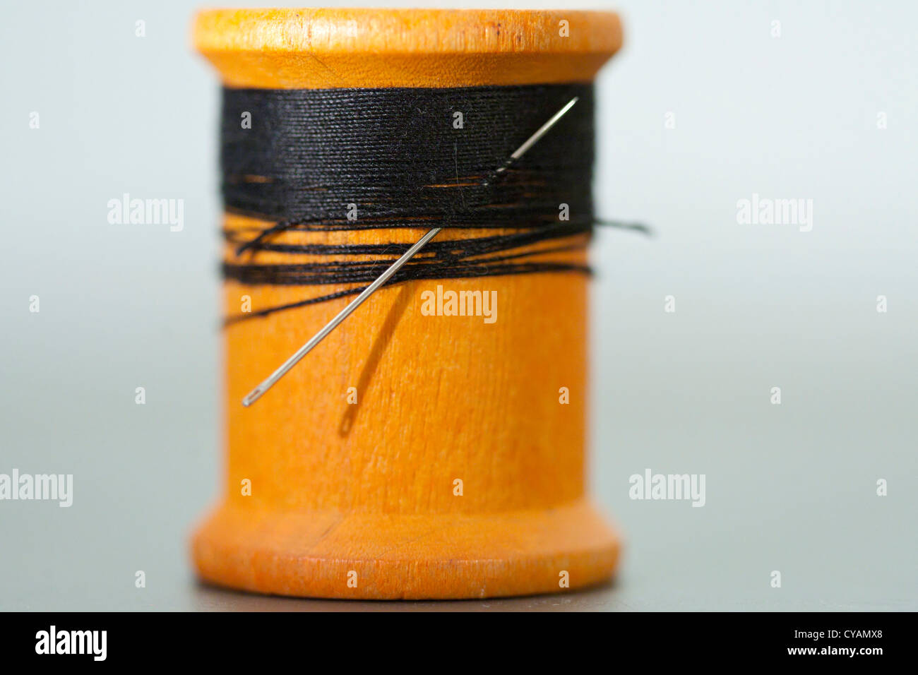 Spool of black thread with needle Stock Photo Alamy