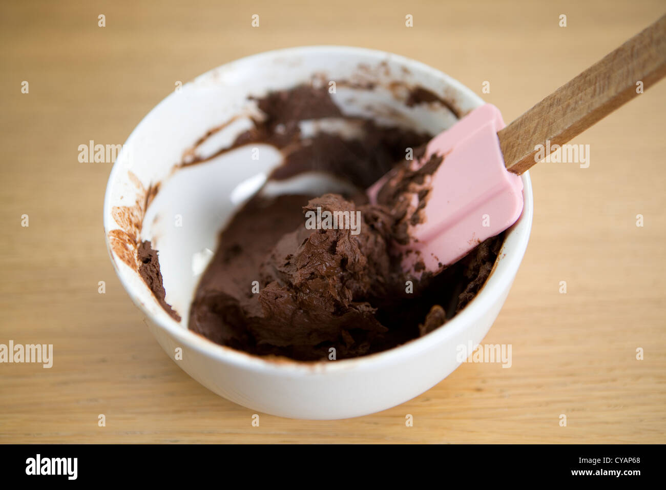 Mixing a paste of cocoa powder and water in a bowl with a rubber