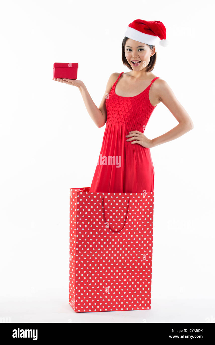 Happy Chinese girl jumping out of a bag wearing a santa hat Stock Photo ...