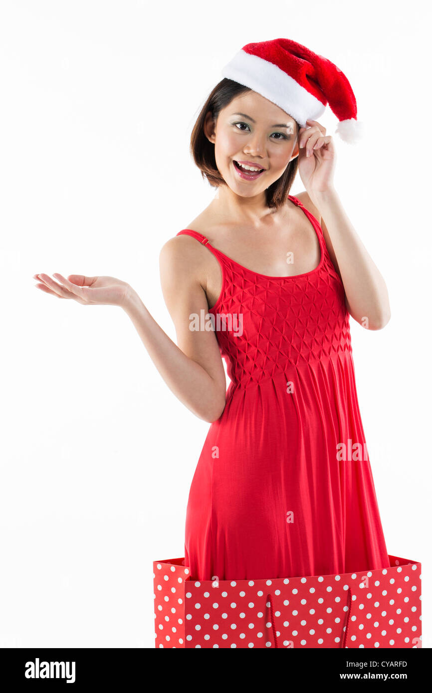 Happy Chinese girl jumping out of a bag wearing a santa hat Stock Photo ...